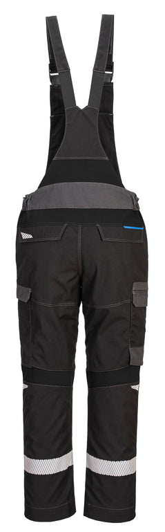 Back of Portwest WX3 Flame Resistant Bib and Brace in Black with grey panels on waistband and pocket flaps on legs. Heat seal reflective strips on legs, pockets on side of legs and bottom with blue zips and straps over shoulders.
