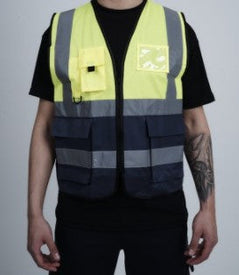 Yellow Hi vis executive vest with two tone accents of navy at the bottom of the vest. Two waist bands and shoulder bands. Zip fasten, Front pockets, D loop and Id badge holder.