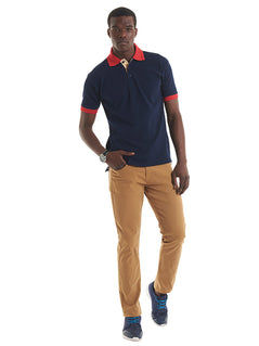 Person wearing Uneek Clothing UC107 - 250GSM Contrast Poloshirt in navy with short sleeves, collar and three button plackett. Collar and hem of sleeves are in red and inside of plackett is white.