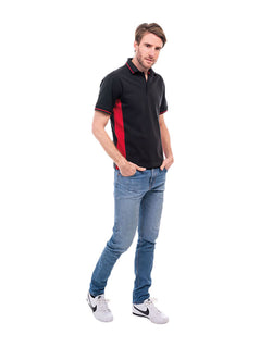 Person wearing Uneek Clothing UC117 200 GSM Two Tone Polo Shirt in black with short sleeves, collar and three button plackett and red panels on sides, inside of collar and sleeves.