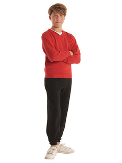 Person wearing Uneek Clothing UC206 300GSM Childrens V Neck Sweatshirt long sleeves and round neck in red with elasticated bottom.