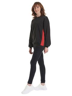 Person wearing Uneek Clothing UC217 280GSM Two Tone Crew Neck Sweatshirt in black with long sleeves, round neck and red panels on sides and inside of neck.