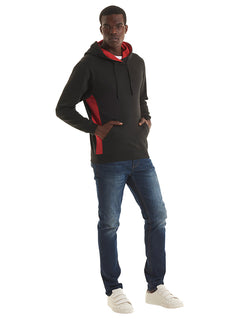 Person wearing Uneek Clothing UC517 280GSM Two Tone Hooded Sweatshirt with hood in black with large front lower pocket, drawstring and red panels on sides and inside of hood.