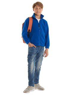 Person wearing Uneek Clothing UC603 300GSM Childrens Full Zip Micro Fleece Jacket in royal blue with full zip fastening and two zipped lower pockets.