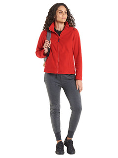 Person wearing Uneek Clothing UC608 Ladies Classic Full Zip Fleece Jacket in red with full zip fastening and and two lower front pockets.