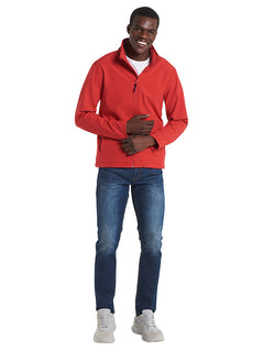 Person wearing Uneek Clothing UC612 Classic Full Zip Soft Shell Jacket in red with full zip fastening and two lower front pockets.