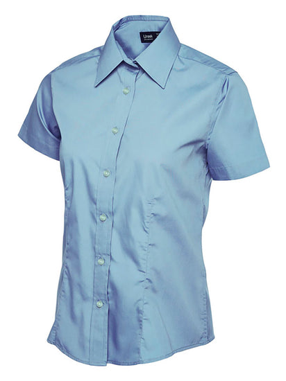 Uneek Clothing UC712 - Ladies Poplin Short Sleeve Shirt in light blue with tailoring on front, collar and light blue buttons down front.