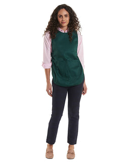 Person wearing Uneek Clothing UC920 Premium Tabard in bottle green with large front pocket and popper side panels.