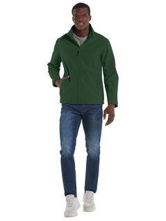 Person wearing Uneek Clothing UX10 The UX Printable Soft Shell Jacket in bottle green with long sleeves, collar, two lower side pockets with zips and full zip fastening.