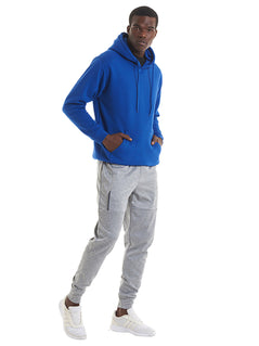 Person wearing Uneek Clothing UC501 - 350GSM Premium Hooded Sweatshirt with hood in royal blue with front pocket and drawstring.